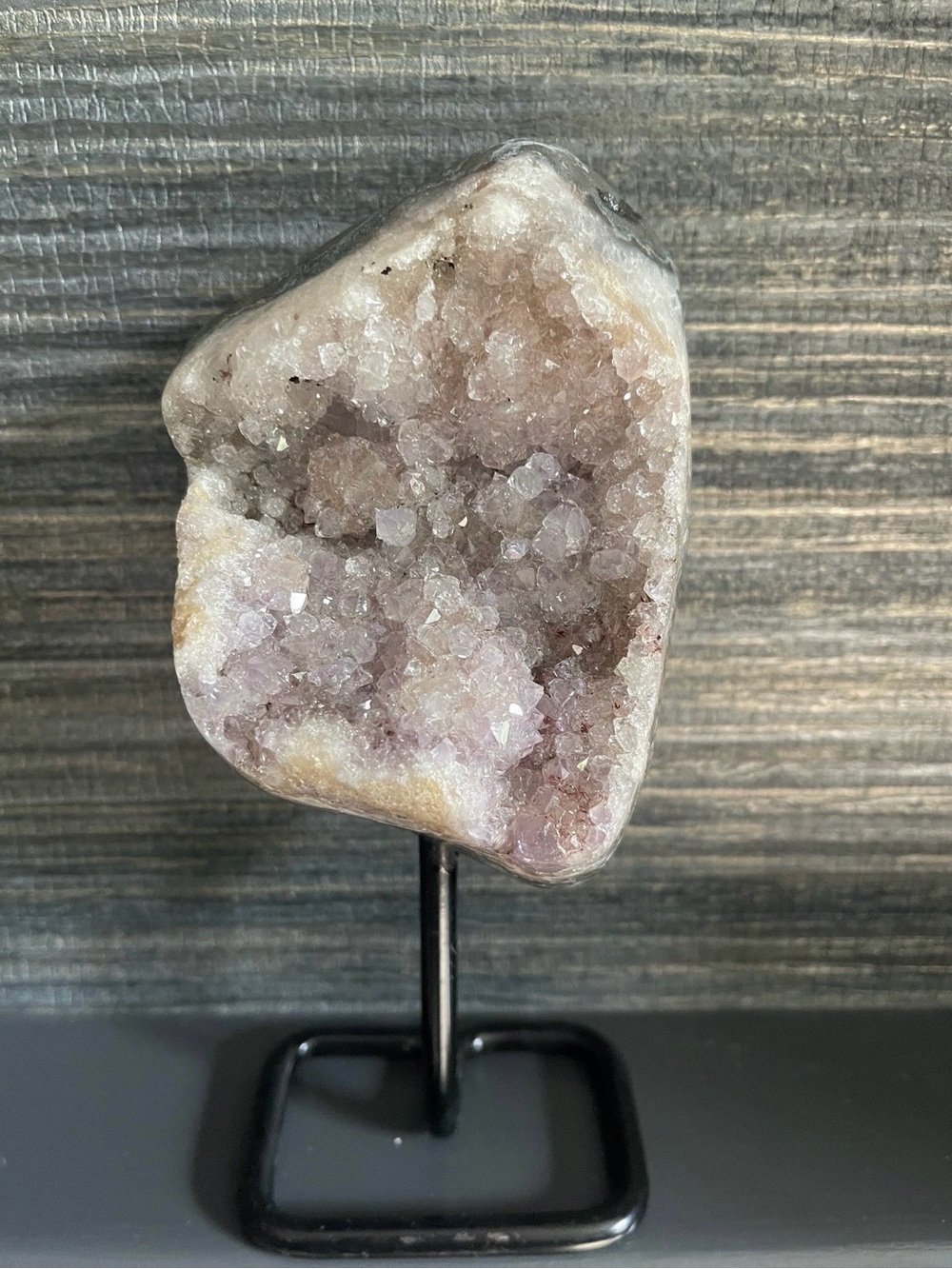 Natural amethyst form on black stand